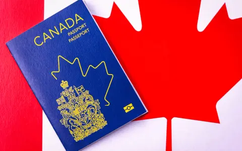 Un passeport canadien bleu sur le drapeau du Canada. Le début d'une nouvelle vie, une aventure pour déménager au Canada.