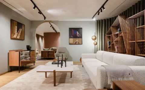Salon moderne avec canapé blanc texturé, table basse en marbre et bois, et étagère design. Une parfaite illustration de la tendance déco actuelle.