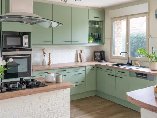 Cuisine vert d'eau et bois, avec des armoires douces, un plan de travail en bois chaleureux et des touches de blanc. Un espace invitant pour cuisiner et partager.