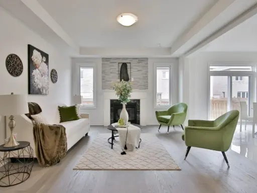 Salon moderne avec canapé blanc, fauteuils verts et cheminée. Idéal pour un conseil décoration intérieur gratuit.