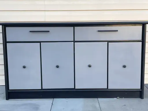 Meuble bas gris et noir avec deux tiroirs et quatre portes. Idéal pour savoir comment vendre ses meubles rapidement.