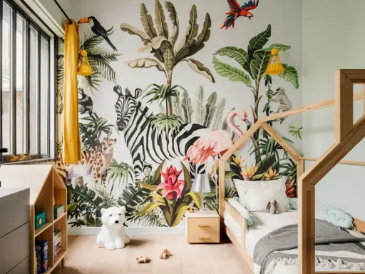 Une chambre d'enfant avec un mur jungle : zèbre, flamant rose, léopard, singe, toucan. Une excellente idée déco chambre enfant pour une aventure tropicale !