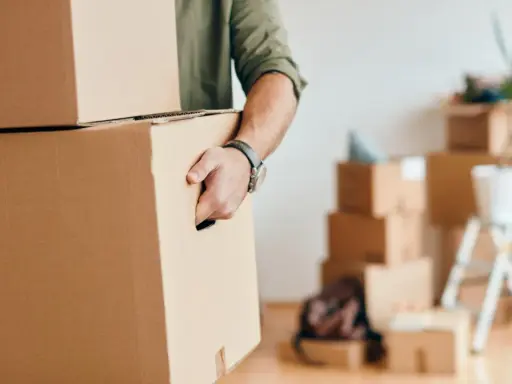 Homme portant des cartons, prêt pour une organisation déménagement longue distance.