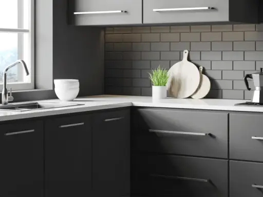 Cuisine moderne avec meubles gris foncés, carrelage métro anthracite et plan de travail blanc. Idéal pour un projet de renover meuble cuisine.