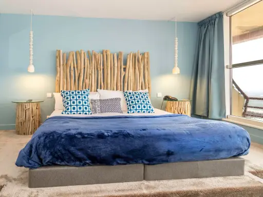 Tête de lit bois à faire soi-même, ambiance bord de mer avec coussins bleus et couverture marine.