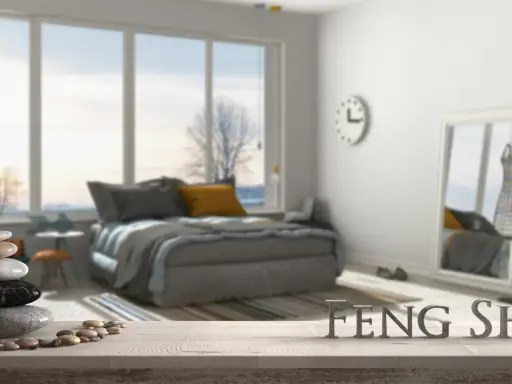 Une chambre apaisante avec un lit douillet, une pile de galets et le mot "FENG SHUI" en lettres métalliques.
