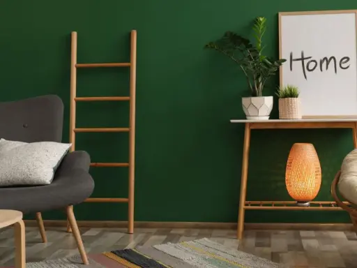 Un salon cosy avec un mur vert sapin, un fauteuil gris, une échelle en bois, une plante et un cadre "Home".