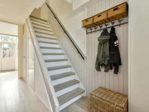 Escalier blanc et gris, avec des marches en bois clair. Une idée pour peindre une cage d'escalier quelle couleur ? Ce style épuré est très tendance.