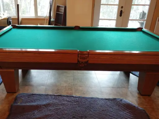 Table de billard français en bois avec tapis vert, prête pour le démontage.