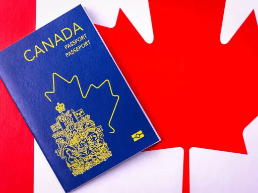 Un passeport canadien bleu sur le drapeau du Canada. Le début d'une nouvelle vie, une aventure pour déménager au Canada.