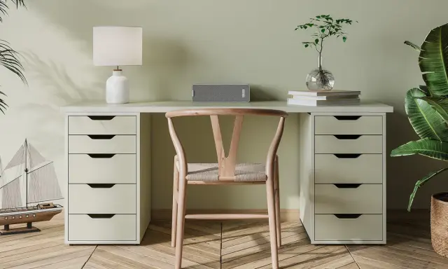 Un bureau DIY épuré avec une chaise en bois, une lampe, un haut-parleur et une plante.