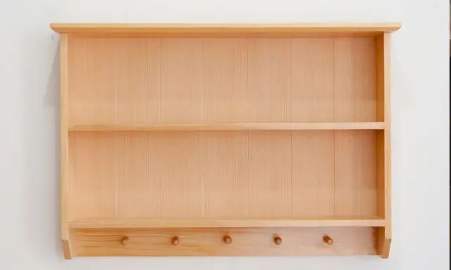 Étagère murale en bois clair, idéale pour fabriquer une bibliothèque personnalisée. Elle possède deux étagères et des patères en dessous.