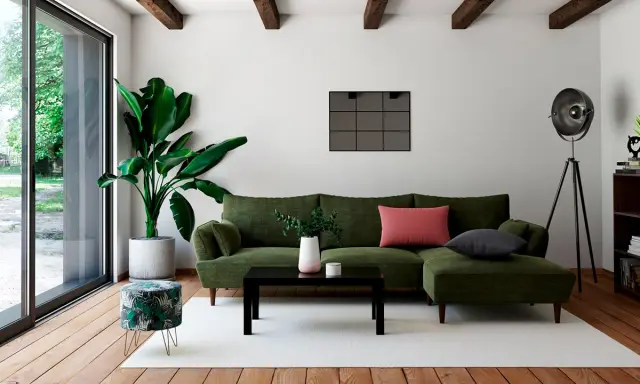 Un salon moderne avec un canapé vert, une table basse noire et un pouf décoré de feuilles tropicales. Quel meuble devant baie vitrée ? Le pouf, parfait pour un coin lecture.