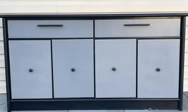 Meuble bas gris et noir avec deux tiroirs et quatre portes. Idéal pour savoir comment vendre ses meubles rapidement.
