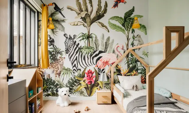 Une chambre d'enfant avec un mur jungle : zèbre, flamant rose, léopard, singe, toucan. Une excellente idée déco chambre enfant pour une aventure tropicale !