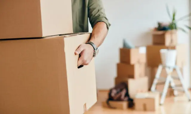 Homme portant des cartons, prêt pour une organisation déménagement longue distance.