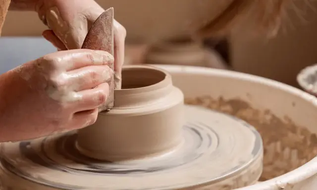 Mains argileuses façonnant un vase sur un tour, une scène d'inspiration peinture céramique.