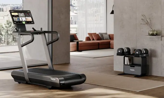 Un tapis de course et des haltères ajustables pour faire une salle de sport chez soi. Un espace moderne et fonctionnel pour le fitness à domicile.