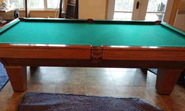 Table de billard français en bois avec tapis vert, prête pour le démontage.