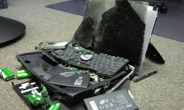 Un ordinateur portable détruit, ses composants éparpillés sur le sol. Un triste exemple de déménagement informatique qui a mal tourné.