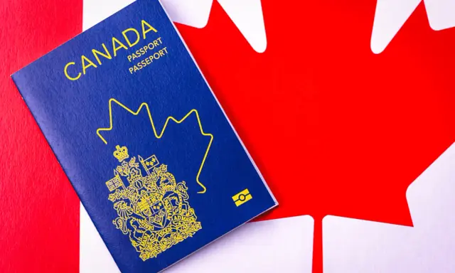Un passeport canadien bleu sur le drapeau du Canada. Le début d'une nouvelle vie, une aventure pour déménager au Canada.