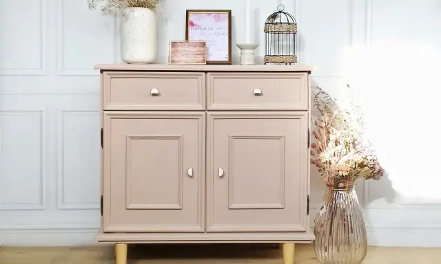Meuble bas rose poudré, prêt à repeindre, avec deux tiroirs et deux portes. Décoré de fleurs séchées et d'une cage ornementale.