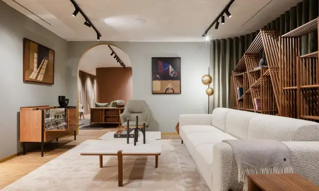 Salon moderne avec canapé blanc texturé, table basse en marbre et bois, et étagère design. Une parfaite illustration de la tendance déco actuelle.