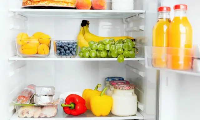 Comment ranger son frigo congélateur en bas : fruits, légumes, viandes et jus bien organisés sur les étagères.