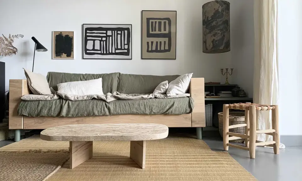 Idée pour fabriquer une table basse originale : un plateau en bois brut aux formes douces, posé sur des pieds minimalistes. Un style épuré pour un salon cosy.