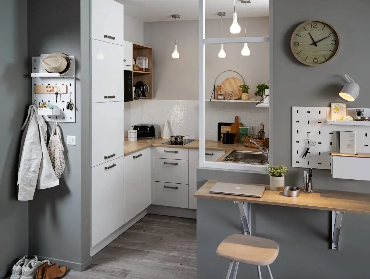 Une cuisine petit espace fonctionnelle avec rangements muraux, un coin repas/bureau pliable et des éléments de décoration modernes.