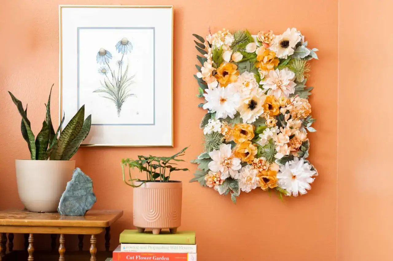 Magnifique décoration printemps à fabriquer avec un arrangement floral mural coloré, une plante verte et un tableau de fleurs bleues.