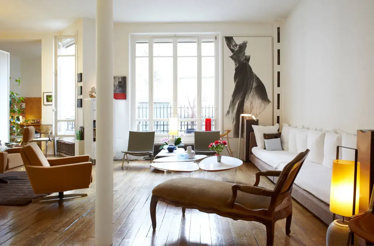 Salon avec un mixer moderne et ancien : fauteuils design, banquette, tables basses et une grande &oelig;uvre d'art.