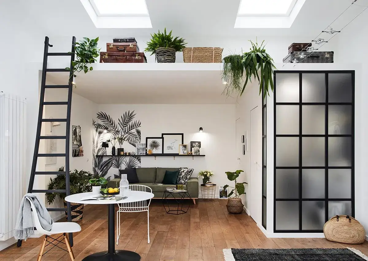 Ce studio de 28 m2 optimis&eacute; offre un coin repas, un salon cosy et une mezzanine accessible par une &eacute;chelle. D&eacute;coration v&eacute;g&eacute;tale et style boh&egrave;me.