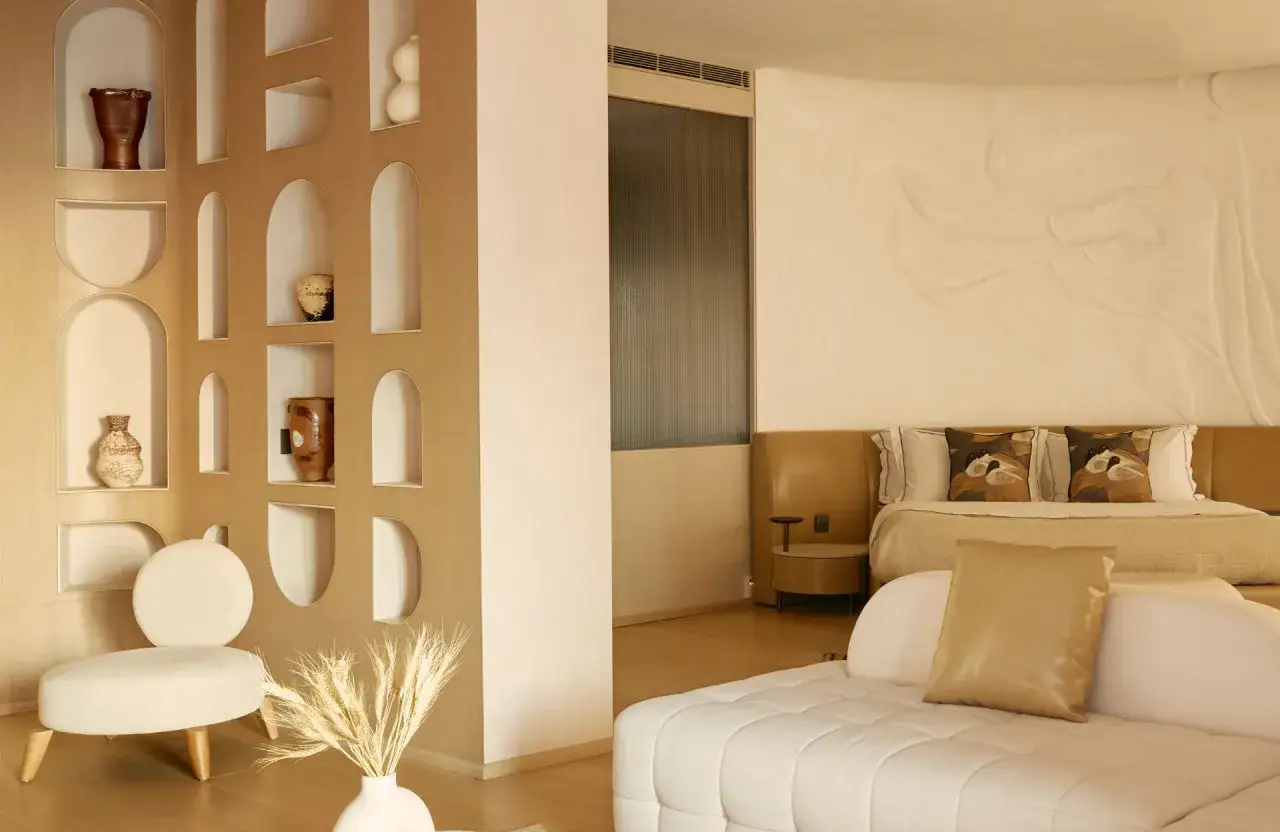 Un coin salon cosy avec une &eacute;tag&egrave;re murale d&eacute;cor&eacute;e et un lit invitant, comme pour s&eacute;parer une petite chambre en deux espaces distincts.