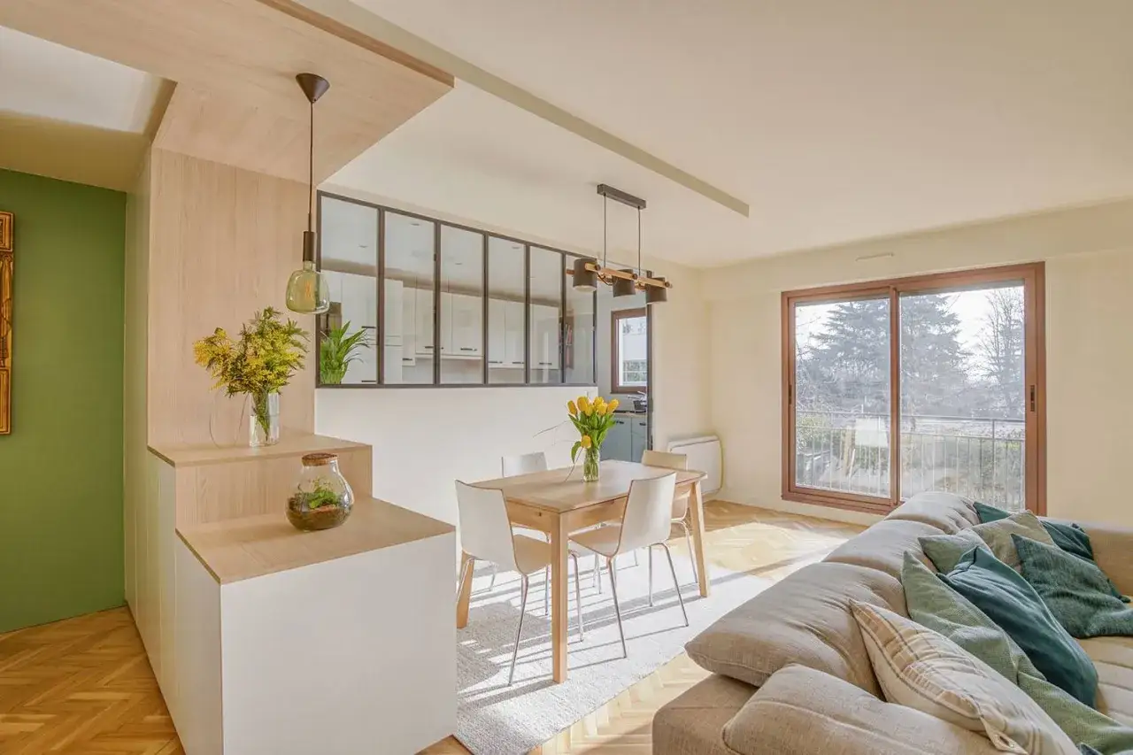 Am&eacute;nagement appartement lumineux avec cuisine ouverte, salle &agrave; manger et salon. Bois clair, touches vertes et vue sur la nature.