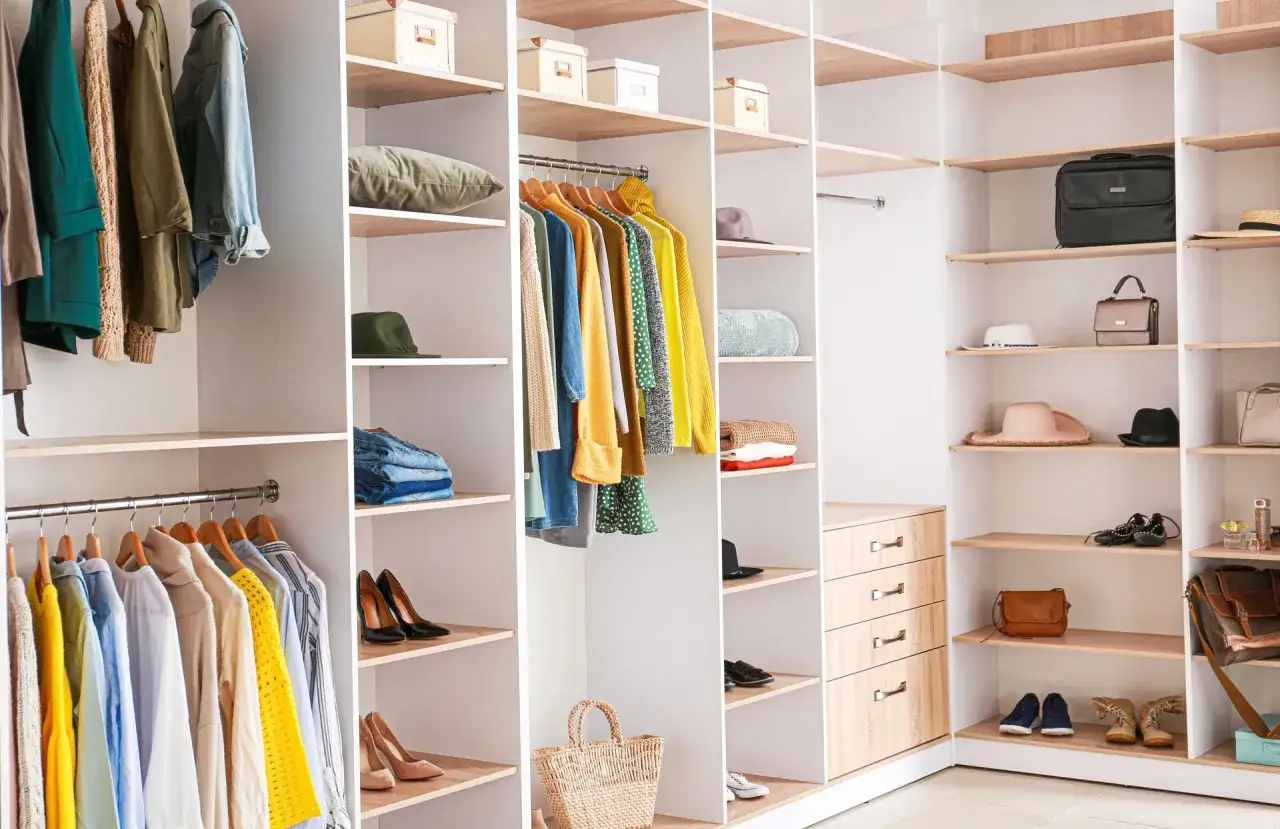 Une chambre avec dressing bien rang&eacute;, remplie de v&ecirc;tements color&eacute;s, de chaussures &eacute;l&eacute;gantes et d'accessoires.