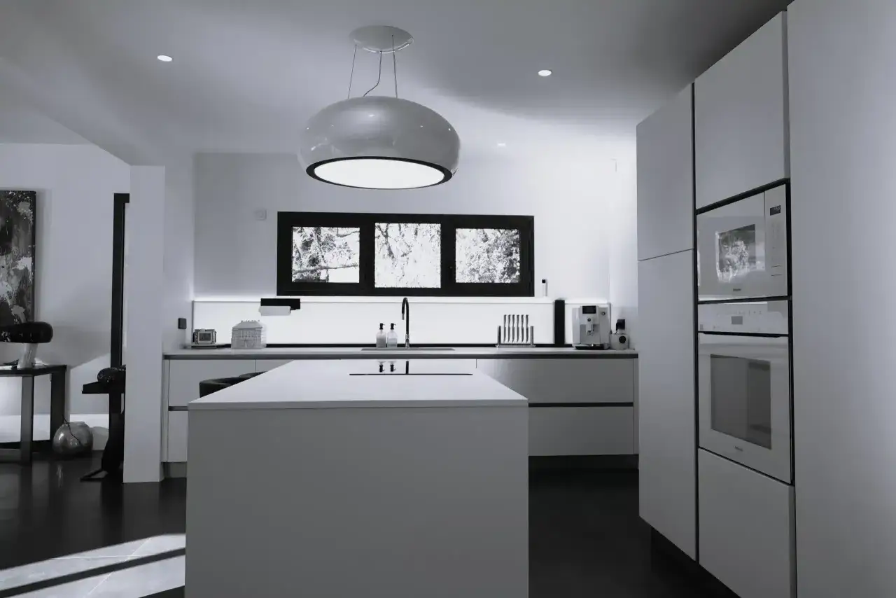 Cuisine moderne 20m2 plan : &icirc;lot central, meubles blancs &eacute;pur&eacute;s, &eacute;lectrom&eacute;nager int&eacute;gr&eacute;, fen&ecirc;tre panoramique et suspension design.