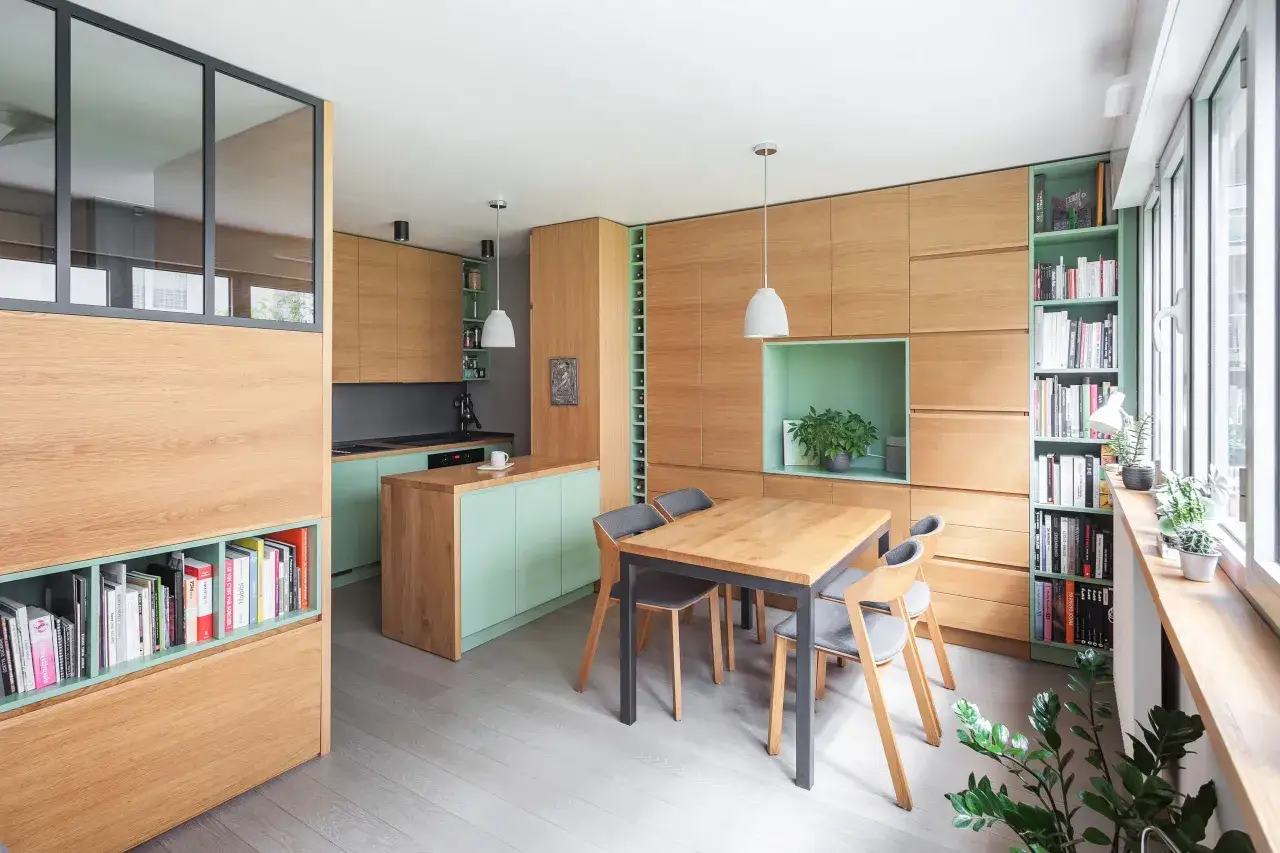 Am&eacute;nagement studio 30m2 : cuisine, salle &agrave; manger et rangements int&eacute;gr&eacute;s en bois clair et menthe.