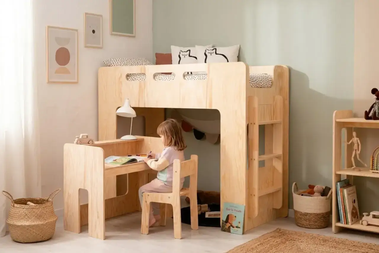 Une petite fille dessine &agrave; son bureau sous un lit mezzanine en bois. Une belle id&eacute;e d&eacute;co chambre enfant, chaleureuse et fonctionnelle.