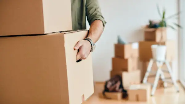 Homme portant des cartons, prêt pour une organisation déménagement longue distance.