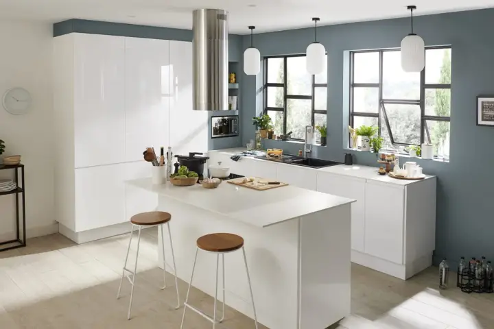 Cuisine moderne avec îlot central, meubles blancs brillants et une magnifique couleur mur cuisine bleu-gris.