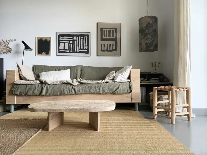 Idée pour fabriquer une table basse originale : un plateau en bois brut aux formes douces, posé sur des pieds minimalistes. Un style épuré pour un salon cosy.