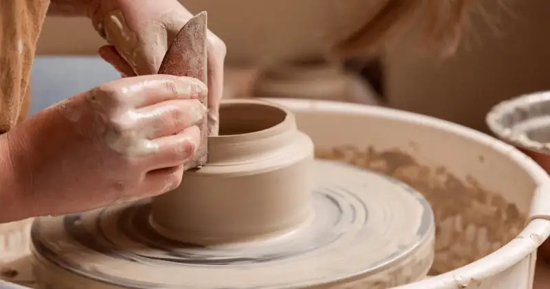 Mains argileuses façonnant un vase sur un tour, une scène d'inspiration peinture céramique.